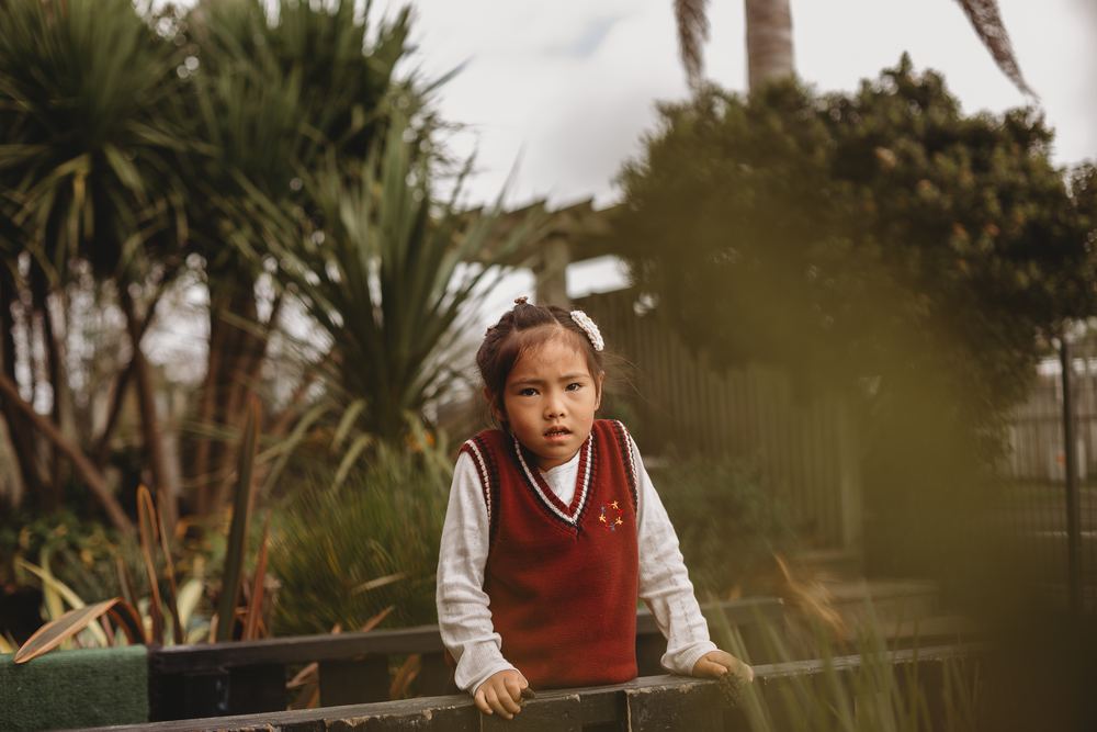 An older child standing among the tall native plants