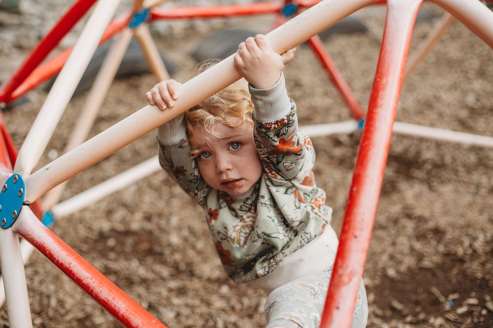 A toddler climbing the dome frame